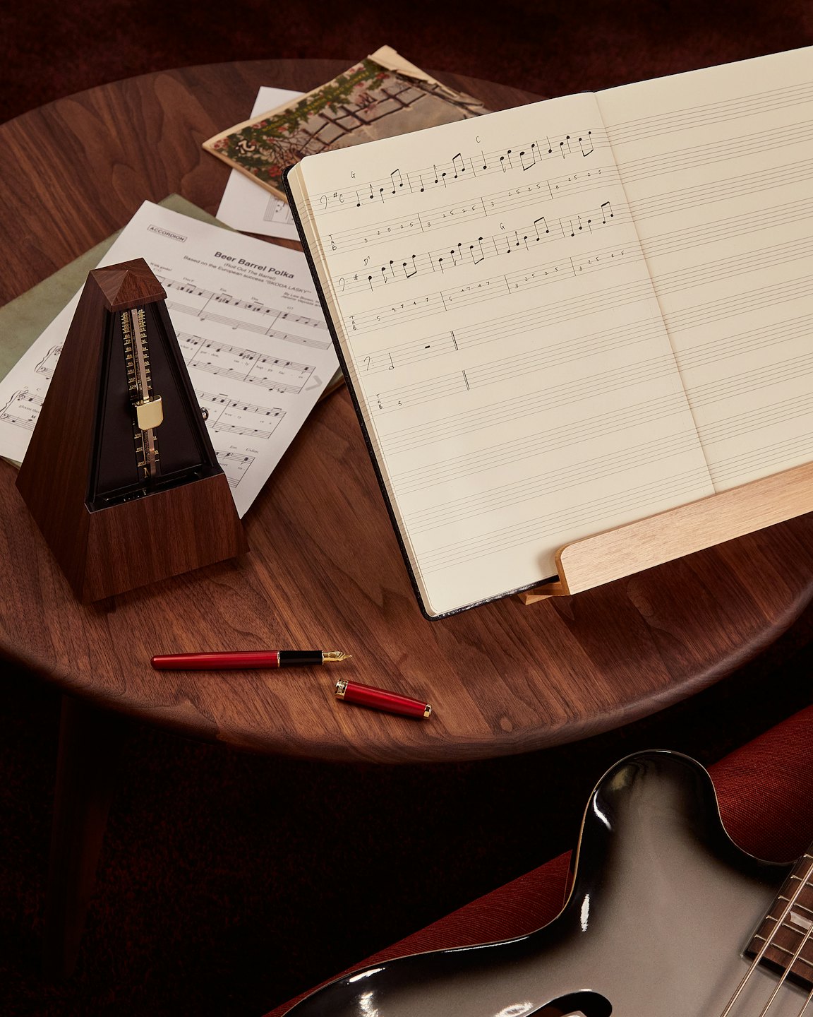 Muziekpartituren en muziekinstrumenten liggen op een houten tafel.
