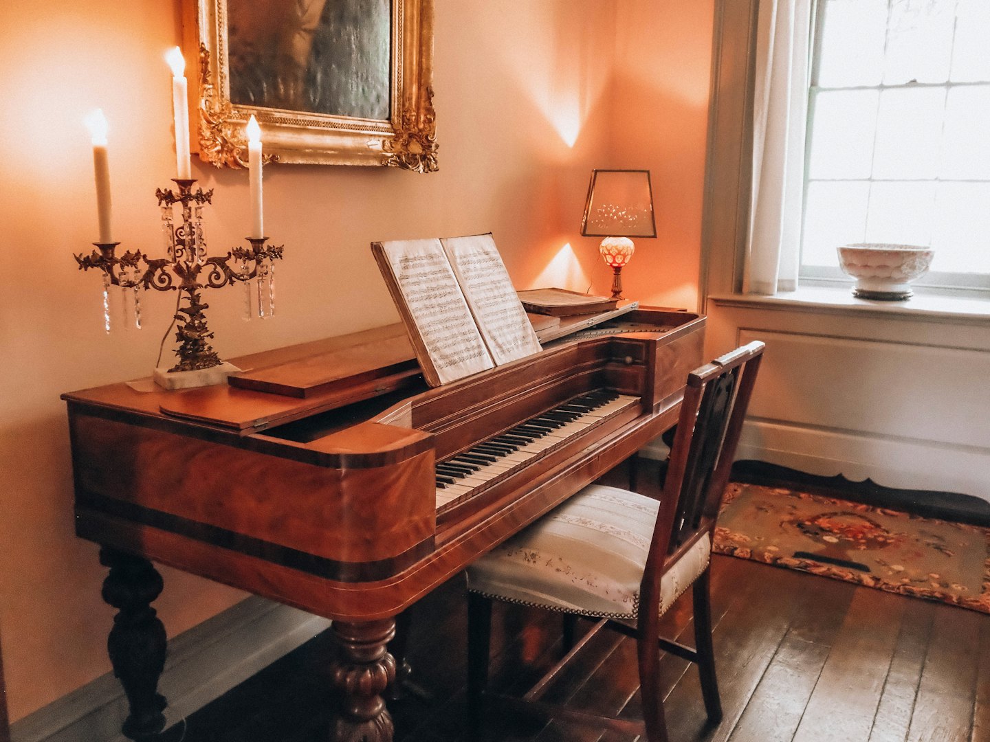 Antieke houten piano met bladmuziek staat in een kamer.